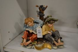 A Capodimonte figure of two children by a tree stump.