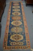 Persian style runner, blue ground with large stylised motifs 315cm x 90cm.