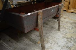 A rustic wooden trough style planter.