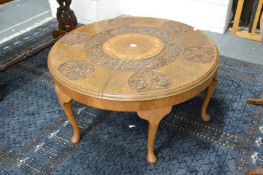 An Eastern teak circular coffee table with brass inlaid and carved decoration.