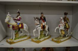 Three porcelain figures on horseback.