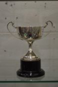 A silver pedestal trophy cup.