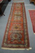 A Persian design runner, red ground with large stylised motifs 330cm x 90cm.