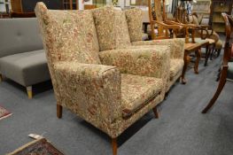 A pair of floral upholstered armchairs (legs repaired to one of the chairs).