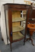 A mahogany bow front display cabinet.