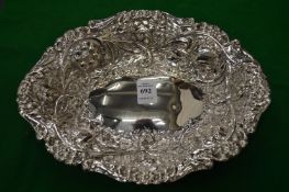 A Victorian silver dish with embossed decoration.
