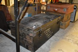 An old metal trunk and three suitcases.