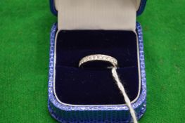 A platinum and diamond half hoop eternity ring.