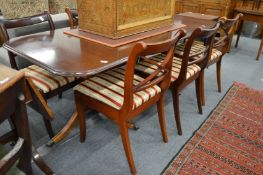 A reproduction twin pedestal dining table with one leaf and six matching dining chairs.
