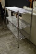 A chrome wire three tier shelving unit.