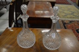 A pair of cut glass decanters and stoppers.