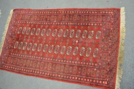 A Bokhara style rug (moth damaged) 155cm x 100cm.