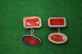 A pair of silver and enamel cufflinks.
