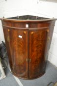 A 19th century mahogany bow front hanging corner cupboard.