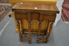A 17th century style walnut credence table with folding top and gateleg action.