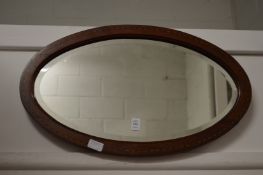 A mahogany oval wall mirror.