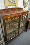 A mahogany two door display cabinet.