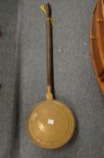 A copper and brass bed warming pan.