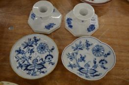 A pair of Copenhagen candlesticks and two Meissen blue and white saucers.