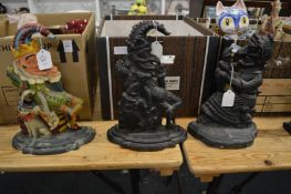 Two Mr Punch cast iron door stops and another of Judy.