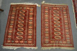 A pair of small modern Bokhara style rugs, each 92cm x 62cm.