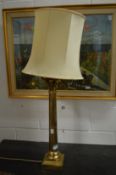 A pair of large brass Corinthian column style table lamps.