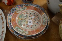 A pair of Japanese porcelain plates and four similar larger plates.