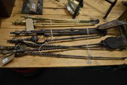 A collection of brass and steel fireside tools.