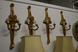 A set of four carved and gilded two branch wall appliques.