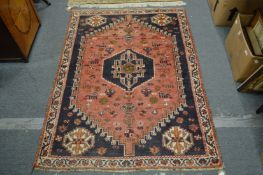 A Persian design rug, pink and blue ground with stylised decoration 160cm x 120cm.