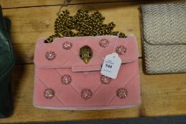 A ladies pink velvet handbag.