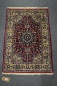 A good small Persian design rug, red ground with stylised decoration 95cm x 64cm.
