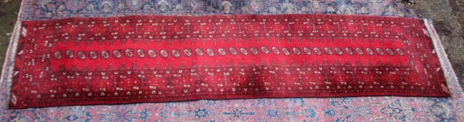 AN UNUSUAL BOKHARA RUNNER, red ground with a central single row of 32 gulls. 11'4