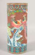 A CHINESE YIXING CYLINDRICAL BRUSH POT, painted with exotic birds, 28.5cm high.