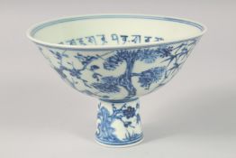 A CHINESE BLUE AND WHITE PORCELAIN STEM CUP, painted with the native flora, the interior with a band