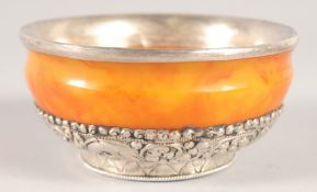 A TIBETAN SILVER MOUNTED AMBER BOWL, 11cm diameter.