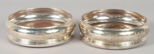 A PAIR OF SILVER WINE COASTERS.