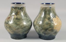 A PAIR OF ROYAL DOULTON STONEWARE GREEN FLORAL VASES. 7ins high.