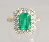 A VERY FINE LARGE EMERALD AND DIAMOND CLUSTER RING, 2.5 carat centre, 18ct gold.