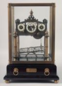 A GOOD REPRODUCTION ROLLING BALL CLOCK in a glass case with wooden stand. 15.5ins high.
