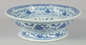 A CHINESE BLUE AND WHITE PORCELAIN FOOTED BOWL, painted with a central floral spray and lotus, the