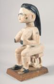 A WHITE PAINTED SEATED CARVED WOOD ASHANTI TRIBAL FIGURE. 15ins high.