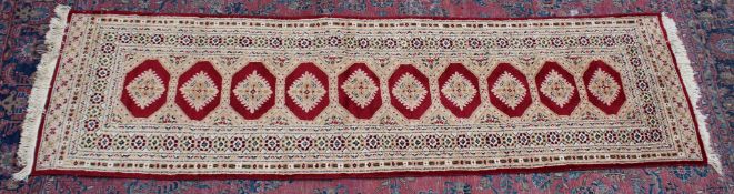 A PERSIAN DESIGN RUNNER, cream and red ground with a single row of ten gulls. 9'0