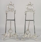 A PAIR OF ORNATE SILVERED EASELS 21ins high