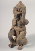 A SMALL KNEELING CARVED WOOD TRIBAL FIGURE. 8.5ins high.