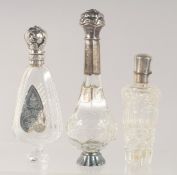 THREE SILVER MOUNTED CUT GLASS SCENT BOTTLES.