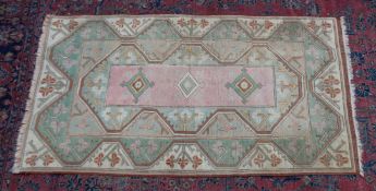 A PERSIAN DESIGN RUG, pastel shades with geometric decoration. 5'7