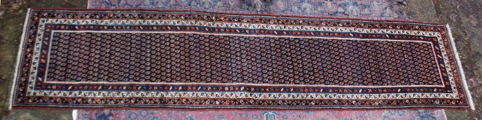 A GOOD PERSIAN RUNNER OR HALL CARPET, rich blue ground with stylised Boteh decoration. 14'9