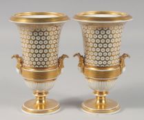 A PAIR OF 19TH CENTURY GILDED TWO HANDLE URN SHAPED VASES. 7ins high.