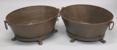 A PAIR OF OVAL METAL PLANTERS with ring handles and paw feet. 29ins wide.